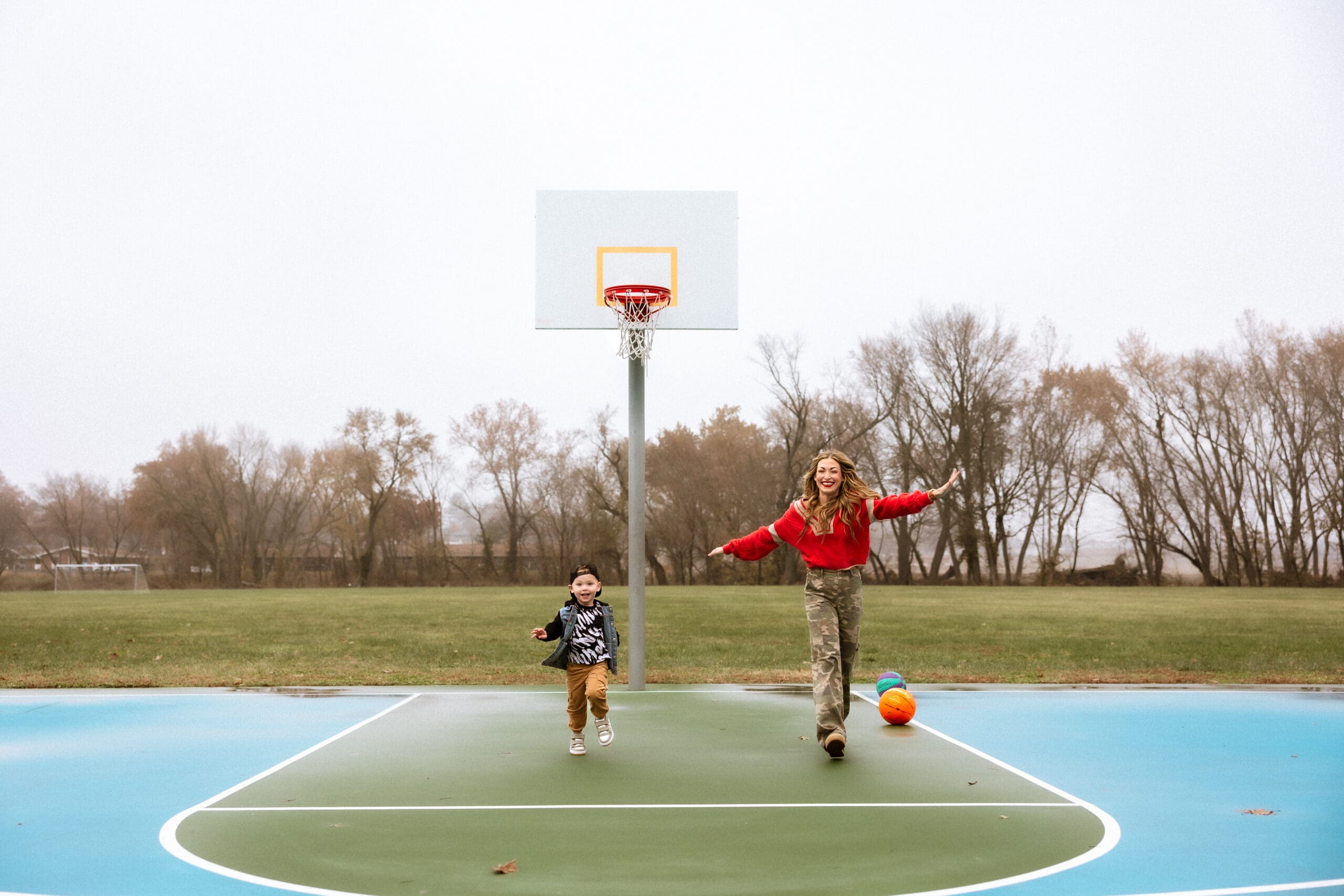 Kansas City family photographer capturing playful moments outdoors at a park located in Smithville, MO