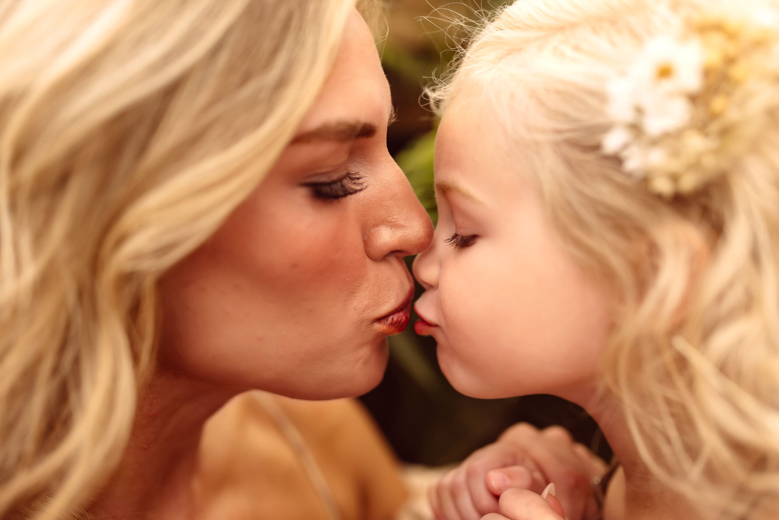 Close- up of a mother and daughter sharing a nose-to-nose kiss during an emotive indoor family photography session in Kansas City, MO