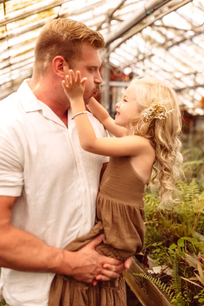 Child playing with her father during an indoor family lifestyle session near Smithville, MO