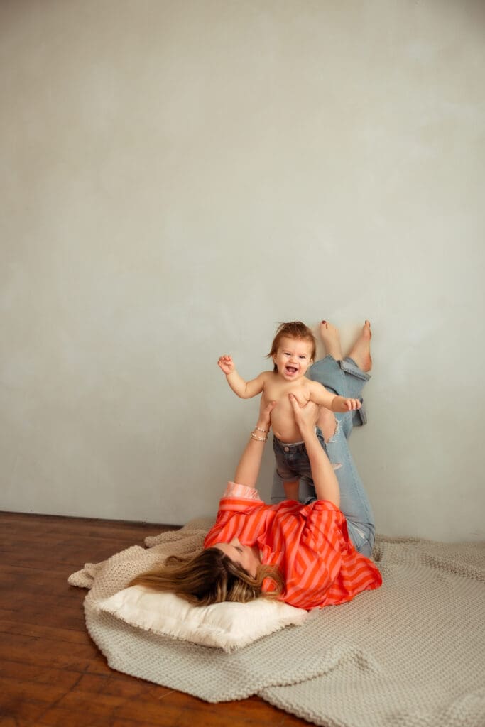 Mom playfully taking candid photos with her son in a studio near Kansas City, MO 