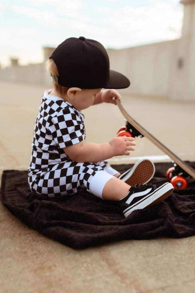 Lifestyle one year family photo session featuring a skateboard and playful moments around Kansas City, MO