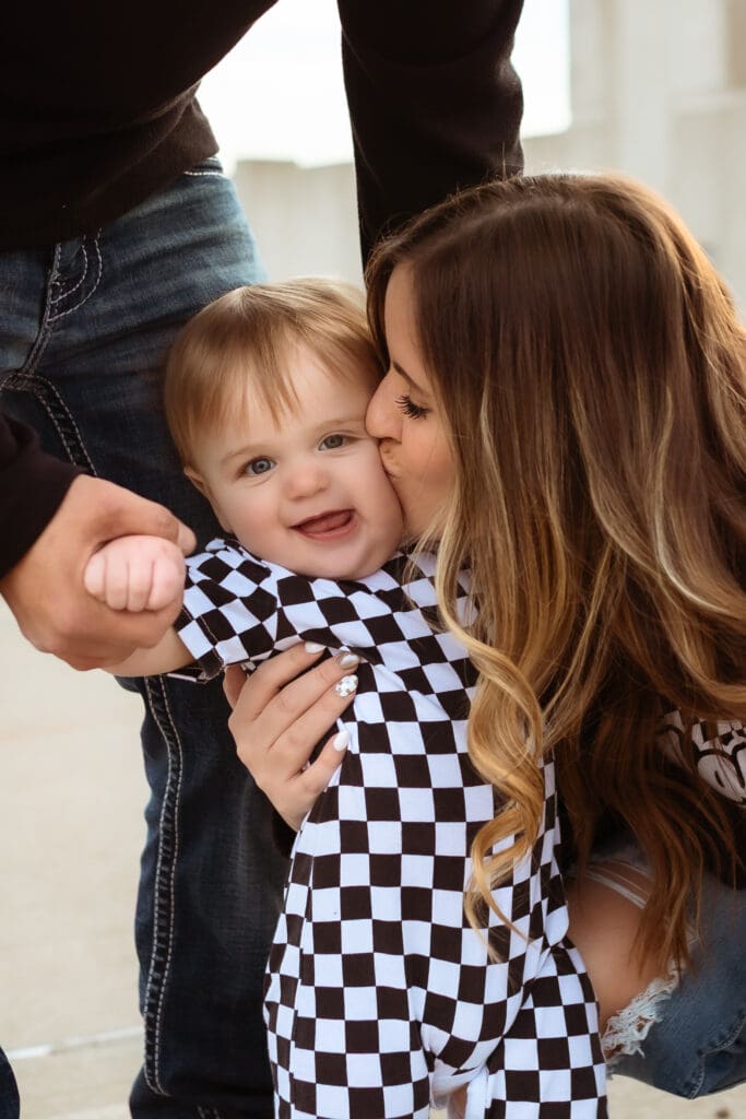 Mom gently kissing her one-year olds son in a playful moment during their lifestyle photography session in Kansas City area