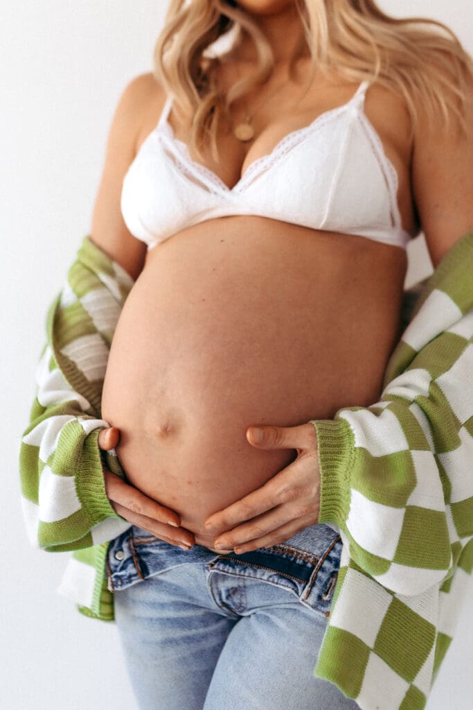 Relaxed studio maternity photos featuring a casual look with soft color accents in Kansas City