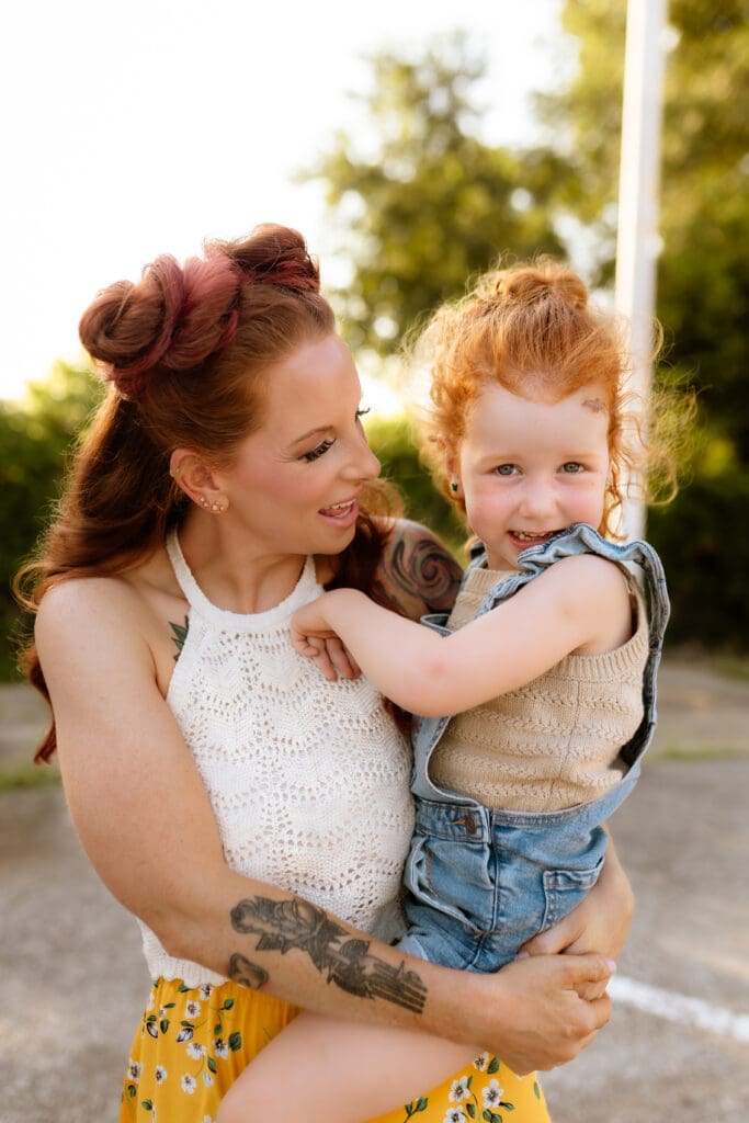 Mother snuggling on her daughter during a lifestyle family photography session in the downtown area of Kansas City