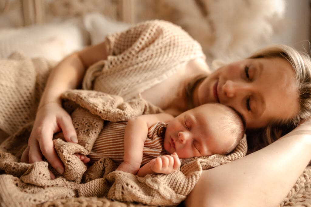 Studio newborn session in Kansas City featuring a mother holding her newborn baby during a lifestyle session.