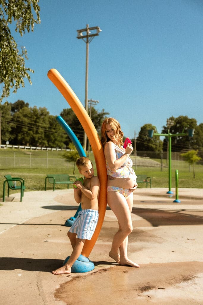 mom and son having a water gun fight at the splash pad in Liberty Missouri